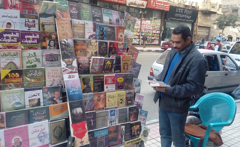 صورة لشاب عند بائع كتب على الرصيف في القاهرة